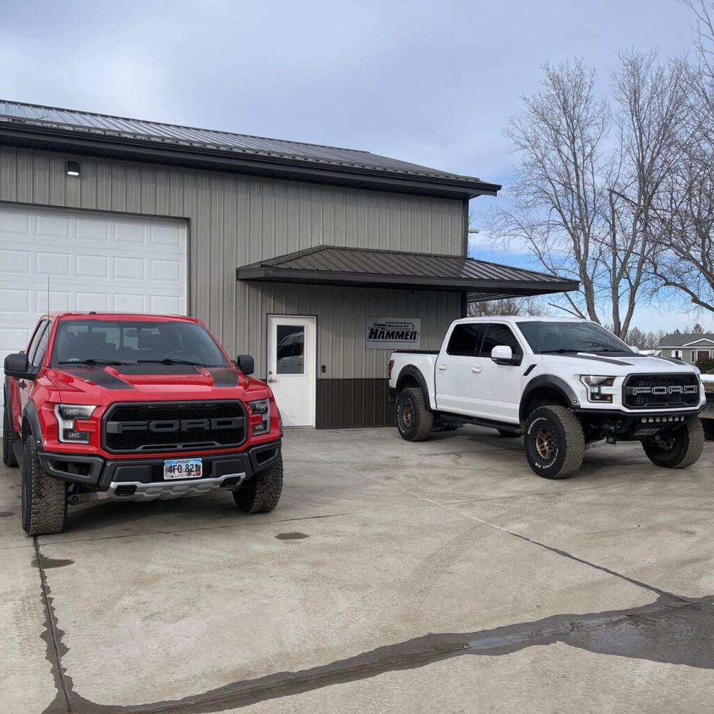 red and white ford raptors parked side by side